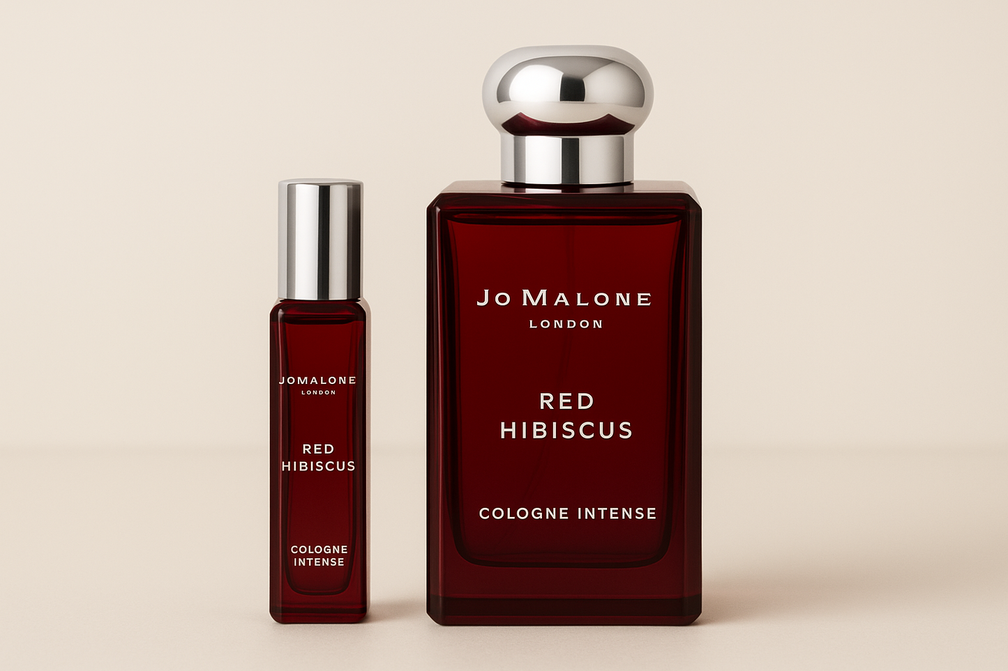 Δείγμα Jo Malone Red Hibiscus Cologne Intense 12ml που στέκεται δίπλα σε μπουκάλι αρώματος 100ml Jo Malone Red Hibiscus Cologne Intense με λευκή γραφή σε σκούρο κόκκινο μπουκάλι