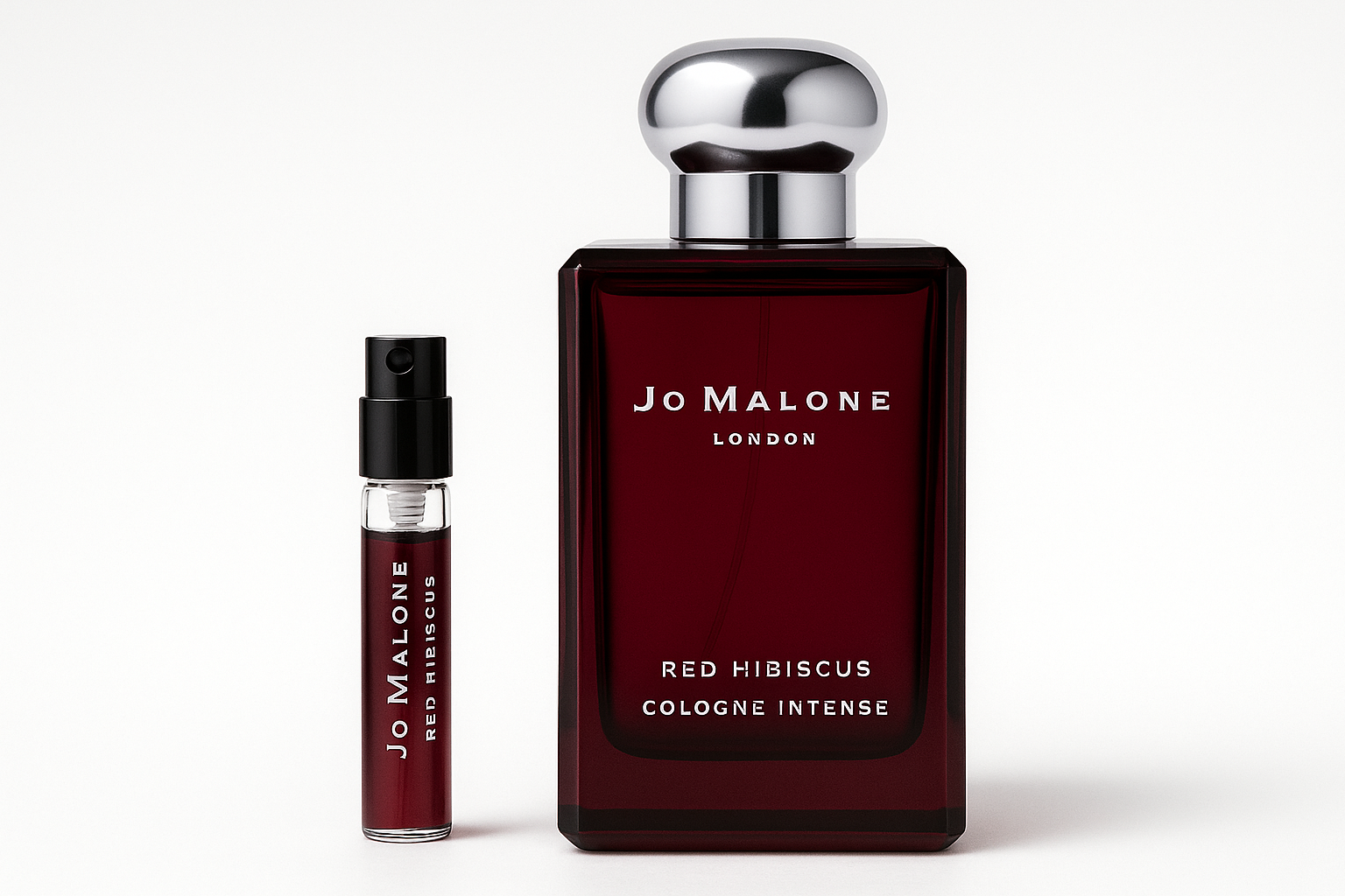 Δείγμα 2ml Jo Malone Red Hibiscus Cologne Intense δίπλα σε μπουκάλι αρώματος 100ml Jo Malone Red Hibiscus Cologne Intense με λευκή γραφή σε σκούρο κόκκινο μπουκάλι